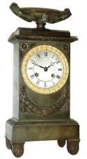 France, Empire period, bronze clock, 8 days, vertical monument motif surmounted by a large urn, and with silvered dial and gilt bezel, silk thread suspended pendulum on well made movement, c1830