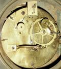France, Empire period, bronze clock, 8 days, vertical monument motif surmounted by a large urn, and with silvered dial and gilt bezel, silk thread suspended pendulum on well made movement, c1830