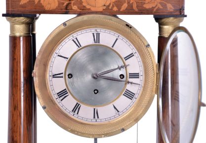 Austria, a mid 19th century portico clock with grand sonnerie striking, the case with rosewood veneers, ripple moldings, and contrasting, foliate marquetry, the columns with cast capitals and bases, Roman numeral silvered dial, blued steel hands, two day brass movement sounding the quarters in passing, and repeating the last hour and quarter on demand, silk suspended pendulum with engine turned rim, and decorative, pierced center