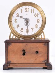 German, Hamburg - American Clock Co., "La Mysterieuse" desk or table clock, rectangular oak base supporting the Arabic numeral transparent dial with brass bezel, movement contained in the base, and driving a second invisible disc to which the motion work is attached, thus driving the hands