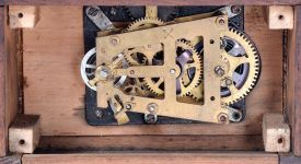 German, Hamburg - American Clock Co., "La Mysterieuse" desk or table clock, rectangular oak base supporting the Arabic numeral transparent dial with brass bezel, movement contained in the base, and driving a second invisible disc to which the motion work is attached, thus driving the hands