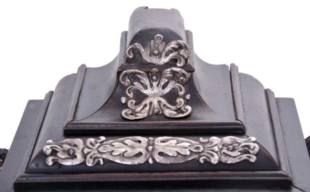 Europe, 18th century, bracket or shelf clock with cow tail pendulum, ebonized wooden case with applied moldings and laden with leaf and scroll, repousse silver ornaments, and case sides with applied scroll ornaments Roman numeral white enamel dial with raised chapter and concave center, fancy pierced and engraved brass hands, brass time and strike movement probably of two day duration, with verge escapement, and engraved, star shaped pendulum swinging in front of the dial