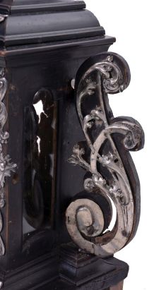 Europe, 18th century, bracket or shelf clock with cow tail pendulum, ebonized wooden case with applied moldings and laden with leaf and scroll, repousse silver ornaments, and case sides with applied scroll ornaments Roman numeral white enamel dial with raised chapter and concave center, fancy pierced and engraved brass hands, brass time and strike movement probably of two day duration, with verge escapement, and engraved, star shaped pendulum swinging in front of the dial