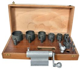 Favorite brand mainspring winder set in a wooden case. Set contains: one winding frame to be held in a bench vise, two cranks, and eight arbors with barrels. For use on clocks and music boxes.