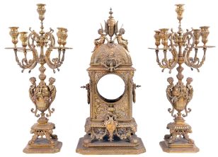 Cast brass clock case with two matching candelabra, 11 (eleven) cast spelter clock toppers and figures, one cast iron standing picture frame, and a cast brass hanging mirror with candle holders.