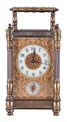 France, carriage clock with alarm, brass case with columns at the corners, turned feet and finials, and blind fret trim at top and base, Arabic numeral white enamel dial with gilt, filigree mask, 8 day time and alarm movement with lever platform, with leather covered outer case