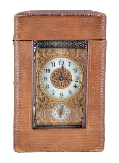 France, carriage clock with alarm, brass case with columns at the corners, turned feet and finials, and blind fret trim at top and base, Arabic numeral white enamel dial with gilt, filigree mask, 8 day time and alarm movement with lever platform, with leather covered outer case
