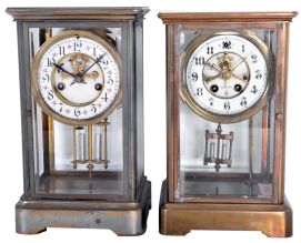 Clocks- 2 (Two) American crystal regulators: (1) William L. Gilbert Clock Co., Winsted, Conn. spring driven, 8 day, time and strike with visible escapement; (2) Unsigned, probably Waterbury Clock Co., Waterbury Conn., 8 day, time and strike, with a visible escapement.