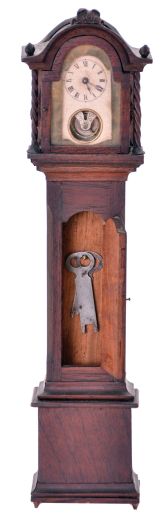 Miniature tall clock, mahogany case with removable bonnet, applied moldings, twist turned columns, and carved finials, Roman numeral paper dial with aperture below revealing the oscillating balance, 30 hour timepiece movement by the Yale Clock Co.