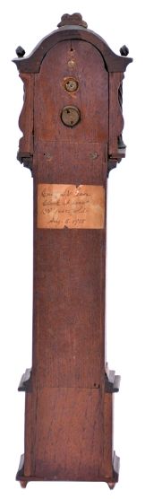 Miniature tall clock, mahogany case with removable bonnet, applied moldings, twist turned columns, and carved finials, Roman numeral paper dial with aperture below revealing the oscillating balance, 30 hour timepiece movement by the Yale Clock Co.