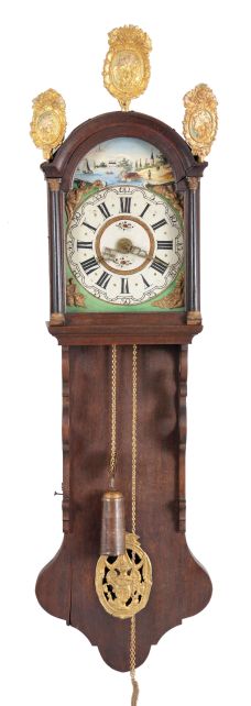 Holland, Staartklok, oak case with arch top bonnet, the door with half columns, gilt capitals and bases, and fancy stamped brass finials, the pendulum aperture with stamped brass ornament, arcaded, Roman numeral painted dial with polychrome landscape shoreline scene in the arch, and with applied, stamped brass figures at the corners, cast brass hands, thirty hour time and strike movement with alarm, tapered, copper clad weight