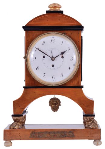 Vienna, Austria, Biedermeier mantel clock with grand sonnerie striking, fruitwood veneer case with ebonized trim and moldings, contrasting line inlay and brass mounts, resting on gilt paw feet, and supported on an oblong base with turned feet, Arabic numeral white enamel dial with date display, 60 hour, three train movement with silk thread suspension and mask pendulum
