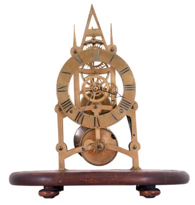 England, small Gothic skeleton clock, the pierced brass frame with 6 turned baluster form pillars, engraved Roman numeral brass dial, blued steel hands, and 8 day fusee timepiece movement, mounted to an oval mahogany base with glass dome.