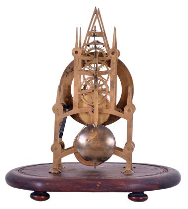 England, small Gothic skeleton clock, the pierced brass frame with 6 turned baluster form pillars, engraved Roman numeral brass dial, blued steel hands, and 8 day fusee timepiece movement, mounted to an oval mahogany base with glass dome.