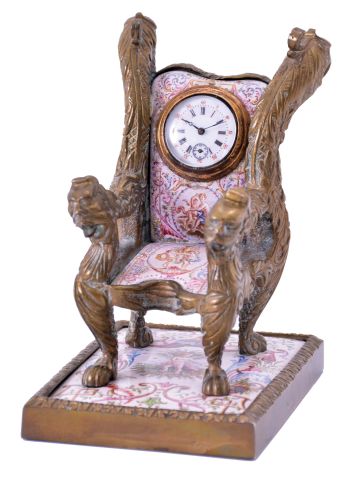 Viennese armchair form desk clock, cast brass case set with polychrome enamel panels, the casting with foliate ornament and griffin heads at upper back, and arms with the heads of other mythical beasts, enamel panels done in typical 19th century Viennese style, with figures, and classical ornament, the chair back set with a 30 hour key wound timepiece
