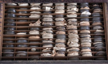 Watchmakers crystal cabinet with contents, walnut, ten drawer cabinet with nickel plated pulls, with a substantial inventory of glass pocket watch crystals, one drawer empty