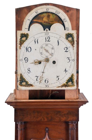 England, unsigned tall clock, 8 day, time and bell strike, weight driven movement, mahogany case with broken arch hood with brass rosettes, convex crotch mahogany panel 3/4 columns on trunk and fan carved crotch mahogany panel on lower plinth with painted metal dial with moon phase, swan spandrels.