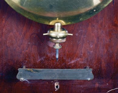 New York Standard Watch Co., Jersey City, New Jersey, electric hanging regulator, walnut case with molded door and base, Roman numeral painted dial with brass bezel, in line movement with Hipp toggle, pendulum with ebonized wooden rod and heavy brass clad ball