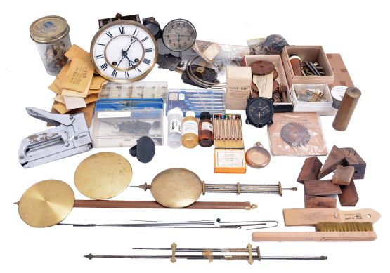 Lot of clock parts and material including pendulum bobs, rods, small tools, a Vienna movement and a car clock and assorted parts.