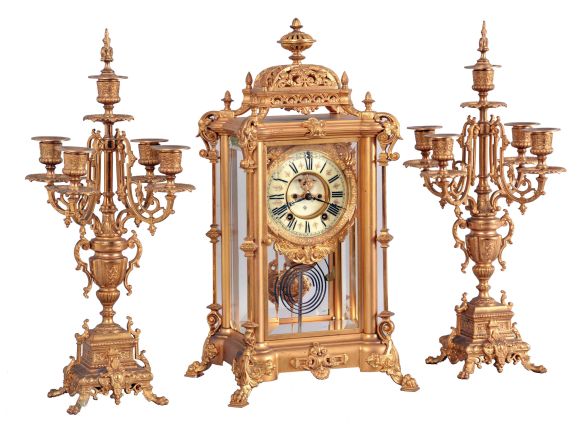 Ansonia Clock Co., New York, NY, "Excelsior" Crystal Regulator with two matching candelabra (No. 1110) with a spring driven, 8 day time and half hour strike movement (rack & snail strike) in a gilt finished brass case.