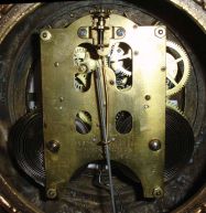 Ansonia Clock Co., New York, NY, "Prosperity" figural mantel clock with a spring driven, 8 day, time and strike movement with visible escapement in a cast metal and enameled iron case.