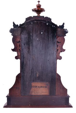 Ansonia Clock Co., New York, NY, "Monarch" mantel clock with 8 day, spring driven time and strike movement, in a walnut case with applied metal ornaments, patented pendulum, and dedication plaque dated 1892.