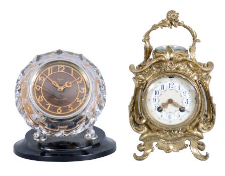 Clocks- 2 (Two) Desk Clocks: (1) France, desk compendium with aneroid barometer and two thermometers, 8 day, time and strike balance wheel movement in a Rococo revival brass case holding a polychrome enamel dial; (2) Majak, USSR, desk clock with balance wheel movement in a Mid-century Modern cut and polished crystal case held by two curved supports mounted to a black plastic base.