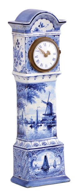 France, ceramic miniature tall clock, the earthenware case with blue, freehand decoration on a white ground, depicting harbor scenes with windmills on the trunk and base, with naturalistic ornament on the bonnet and base sides, Roman numeral white enamel dial with gilt Louis XV style hands, 8 day timepiece movement with cylinder platform, case bottom with makers mark