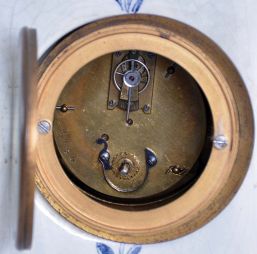 France, ceramic miniature tall clock, the earthenware case with blue, freehand decoration on a white ground, depicting harbor scenes with windmills on the trunk and base, with naturalistic ornament on the bonnet and base sides, Roman numeral white enamel dial with gilt Louis XV style hands, 8 day timepiece movement with cylinder platform, case bottom with makers mark