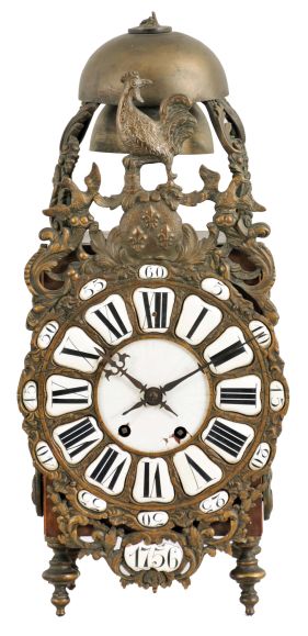 France, lantern clock, walnut case with ornate cast front incorporating the dial, side frets with rococo ornament, and top with fancy bell cage and two bells, surmounted by a rooster finial, Roman numeral white enamel cartouche dial with enamel center, blued steel hands, 8 day, time and strike movement with square plates