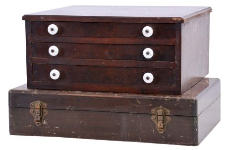 Watchmakers storage cabinets, the first an interesting, three drawer in walnut with porcelain pulls, the interior with sliding compartment covers, the top of each drawer marked Pat. March 2 1875, the other originally containing Elgin ordnance wrist watch repair material, some bottles containing parts from the original assortment, some empty or containing other material, dimensions of 3 drawer cabinet listed