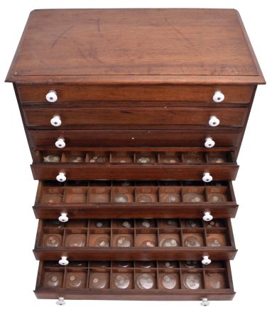 Watchmakers 7 drawer crystal cabinet in walnut with porcelain knobs, containing open face and hunting case crystals ranging in size from15 - 21
