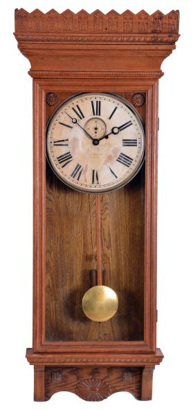 William L. Gilbert Clock Co., Winsted, Conn., "Regulator No. 14" hanging clock with a weight driven 8 day timepiece movement with dead beat escapement and retaining power, in an oak case.