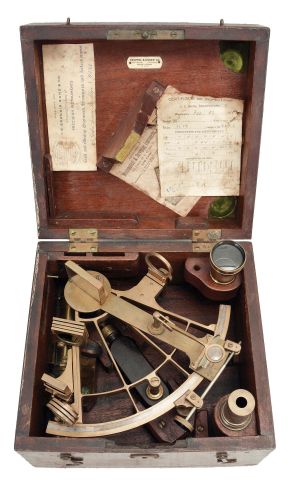 Keuffel & Esser Co., New York, for U.S. Navy, brass sextant, 6 inch radius, pierced brass frame, signed brass arc with inset silvered arc graduated from -5 to 145, outboard tangent screw for vernier adjustment, index with magnifier and frosted glass shade, multiple shades for index and horizon mirrors, three sighting telescopes, and ebony handle, all in a dovetailed mahogany box with accessories, inset Naval plaque, paper labels, and certificate under the lid dated 1918.