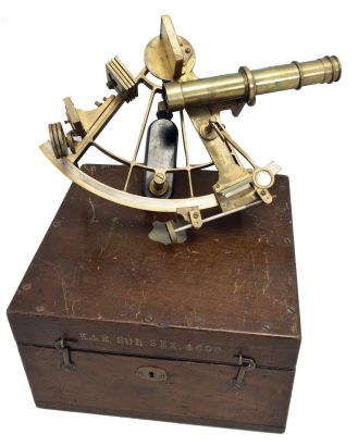 Keuffel & Esser Co., New York, for U.S. Navy, brass sextant, 6 inch radius, pierced brass frame, signed brass arc with inset silvered arc graduated from -5 to 145, outboard tangent screw for vernier adjustment, index with magnifier and frosted glass shade, multiple shades for index and horizon mirrors, three sighting telescopes, and ebony handle, all in a dovetailed mahogany box with accessories, inset Naval plaque, paper labels, and certificate under the lid dated 1918.