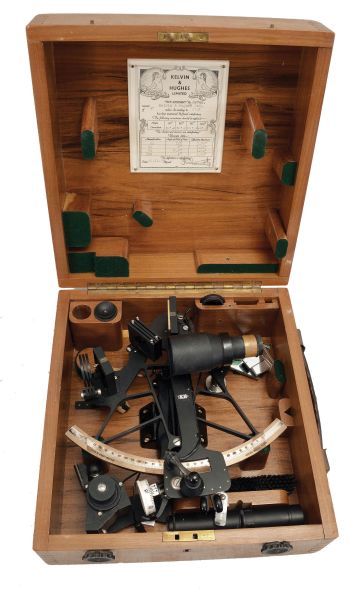 Kelvin & Hughes Ltd., London, 7 inch radius sextant, pierced black metal frame, signed brass arc with inset silvered arc graduated from -5 to 125, index arm with K&H logo, micrometer drum vernier adjustment, index lamp, multiple shades for index and horizon mirrors, sighting telescopes, auxiliary lamp, and black plastic handle with battery compartment all in a finger-jointed case with certificate under the lid dated 1955.
