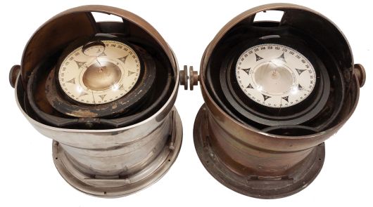 Instruments- 2 (Two) Brass Binnacles: John E. Hand, Philadelphia, gimbal-mounted 6.5 inch wet-card compasses within heavy brass bases, one nickel plated, dome tops with knurled hand screws and sliding doors to cover viewing port, both electrically illuminated.
