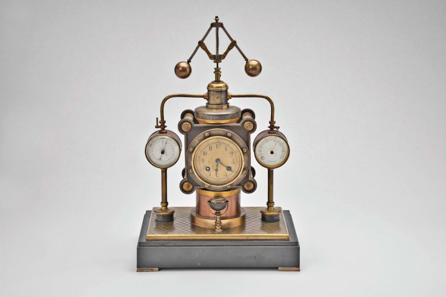 France- Andre Romain Guilmet, a rare Industrial steam boiler compendium with centrifugal governor pendulum, the stepped black slate base supporting a compass on a decorative stand, before a boiler with gilt and patinated silver surfaces and ribbed, copper base matching the clock case, the top having a cylindrical chamber with vent pipes attached to gauge form, flanking, white dialed thermometer and barometer, and concealing the helical suspension spring controlling the centrifugal governor form pendulum, Arabic numeral gilt dial, blued steel distaff hands, and 8 day pendule de Paris time and strike movement with Guilmet