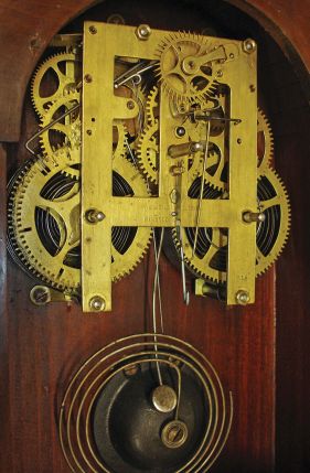 Brewster & Ingrahams, Bristol, Conn., Gallery hanging clock with an 8-day spring driven East-West timepiece movement with a brass spring in a crotch mahogany case.