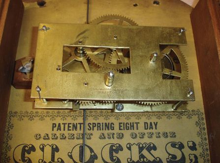 Brewster & Ingrahams, Bristol, Conn., Gallery hanging clock with an 8-day spring driven East-West timepiece movement with a brass spring in a crotch mahogany case.
