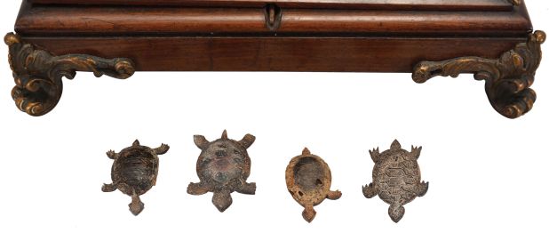 A. Cadot, Place Dauphine, Paris, a mahogany, gilt bronze mounted, floating turtle mystery clock, the case with square base on cast scroll feet, the upper portion with incurved sides with bronze mounts and molded top, supporting a water filled pewter bowl, the rim with engraved roman numerals, and arabic 15 minute markers, the turtle floating, and indicating the time, driven by a magnetic ring attached to the timepiece movement with lever platform concealed in the base, the back plate signed Samuel Marti, the front with Cadot