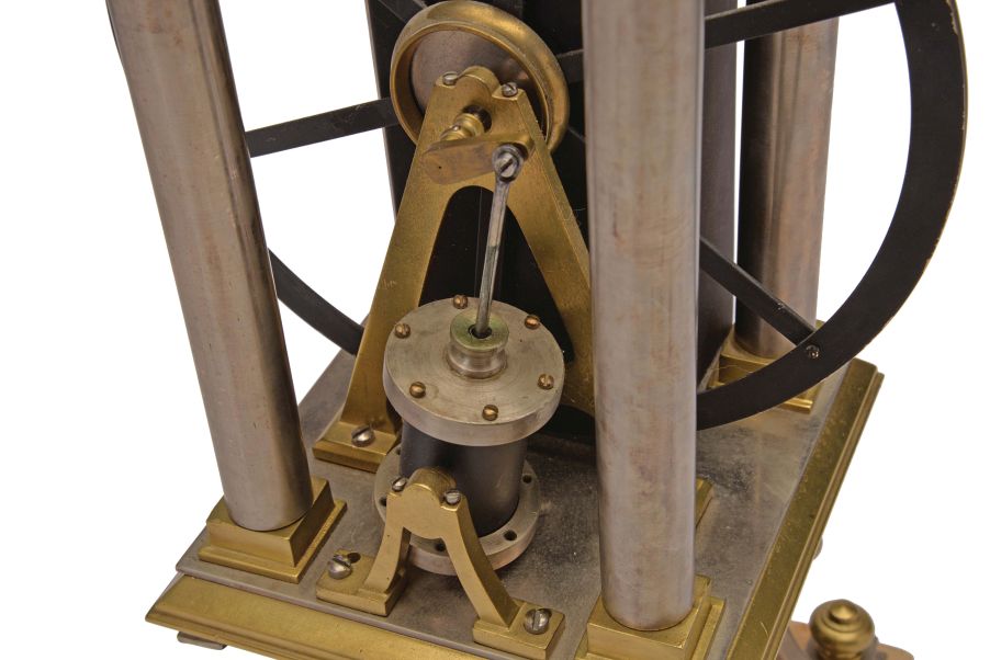 France, possibly Andre Romain Guilmet, a rare, automated, oscillating cylinder steam engine timepiece, the honey onyx square base on gilt feet, and supporting the black bronze boiler with cove molded top and bottom, below the engine itself, comprised of a large, A frame supported, spoked flywheel, connected to a rocking cylinder through a cranked linkage, the movement powering the automation contained in a black enclosure behind the engine, the enclosure top with a rotating governor in a bell shaped frame behind the wheel, surrounded by four silvered columns, and surmounted by an X shaped, arched frame with central spherical finial, the 11 jewel lever platform movement with Roman numeral silvered dial and blued steel Breguet style hands