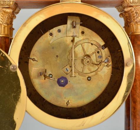 France, portico clock, 8 day, time and strike, round spring driven movement in a figured hardwood veneer case with satinwood inlay on the front, cast leaf moldings on the base, columns, pendulum, and bezel, roman numeral silvered dial with guilloché center, blued steel Breguet style hands