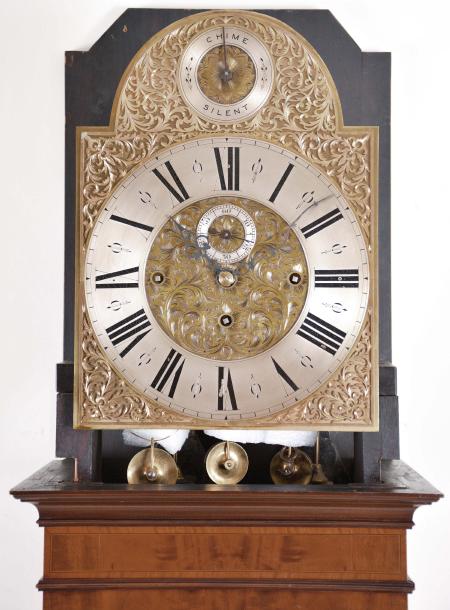 England, a good early 20th century inlaid mahogany tall clock, the bracket feet supporting a base with mahogany and satinwood cross-banded frame with inset panel having floral marquetry and scrolled foliate border, the trunk door also with satinwood cross-banding surrounding a neoclassical urn with bellflower and trailing vine, terminating in a lion