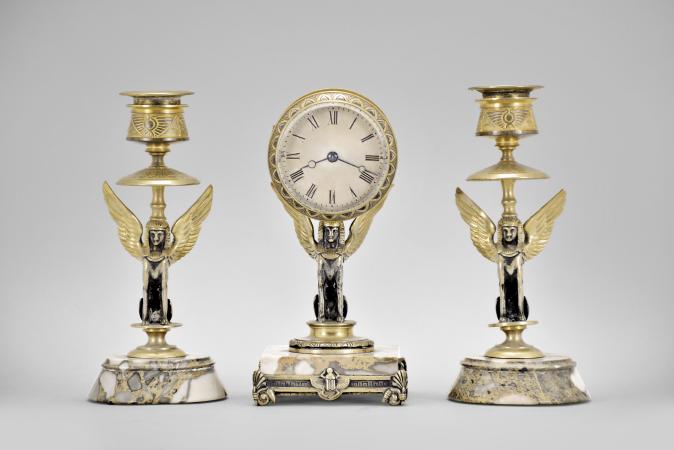 France, Egyptian Revival three piece garniture, 8 day, time only, spring driven brass movement with cylinder escapement in a brass drum supported by a cast winged sphinx figure seated on a variegated marble base with cast moldings, silvered roman numeral dial, and Breguet style blued steel hands