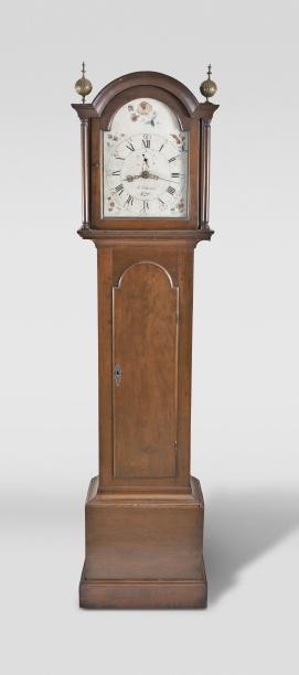 Abraham Edwards, Ashby, Mass., tall clock, 30 hour, time, strike and calendar, weight driven wooden movement in a cherry case with arched top, two brass finials and full columns flanking hood, tombstone trunk door all resting on a molded base with painted wooden dial