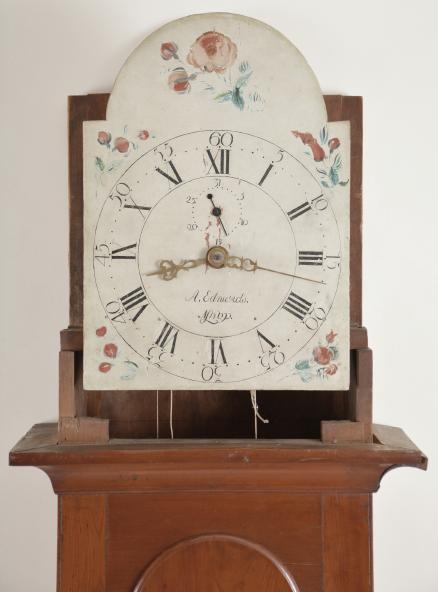 Abraham Edwards, Ashby, Mass., tall clock, 30 hour, time, strike and calendar, weight driven wooden movement in a cherry case with arched top, two brass finials and full columns flanking hood, tombstone trunk door all resting on a molded base with painted wooden dial