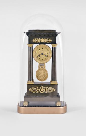 France, empire portico clock, 8 day, time and strike, spring driven brass pendule de Paris movement in a patinated brass case on cast brass feet, the base and top with applied gilt floral ornaments, four Corinthian columns with gilt bases and capitals, the gilt bezel with repeating rose-and-leaf design, roman numerals, cast dial center, pendulum with knife-edge suspension, blued steel Breguet hands, all on a painted wood base under a glass dome.