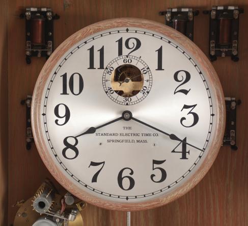 Clocks- 2 (Two) master: (1) Standard Electric Time Co., Springfield, Mass., master clock, time only, electrically driven brass movement in an oak case with a heavy nickel plated pendulum bob and silvered metal dial with subsidiary seconds and movement viewing aperture, c1920 (2) Standard Electric Time Co., Springfield, Mass., master clock, time only, electrically driven brass movement in an oak case with painted metal dial with subsidiary seconds and movement viewing aperture, c1930.
