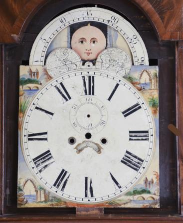 Parts- 2 (Two) tall clock cases: (1) Unknown, England, tall clock case and dial, walnut veneer case with turned half columns flanking the door together with painted metal dial with moon phase and date; (2) English tall clock case in dark wood, stepped base and swan